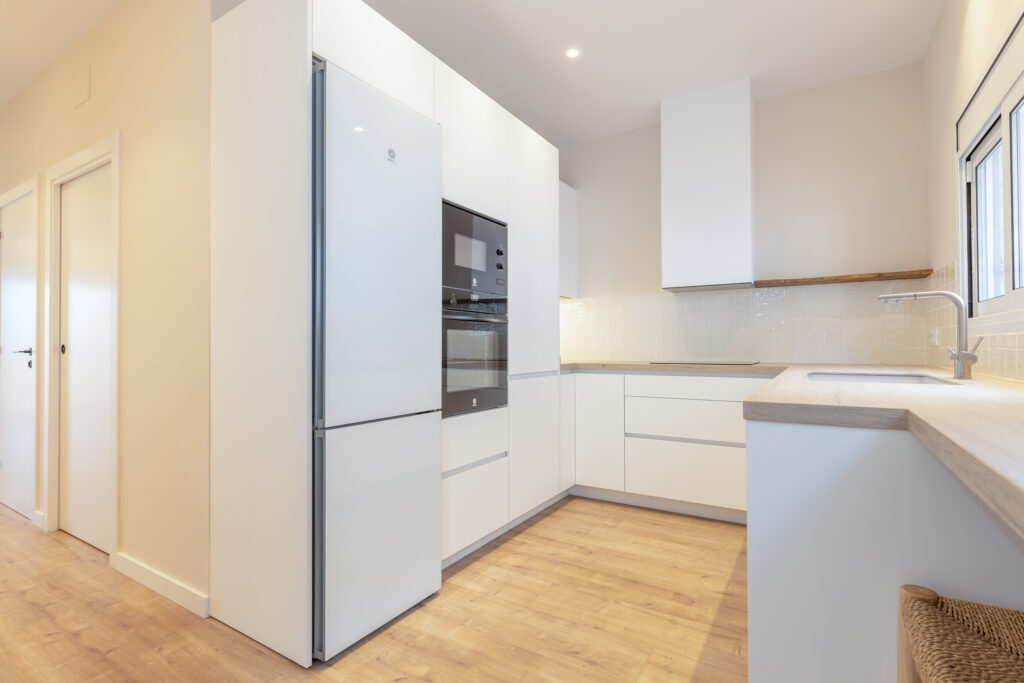 fotografía de interiorismo en Barcelona, fotografía de cocina moderna y reformada, muebles blancos, piso de parqué.
