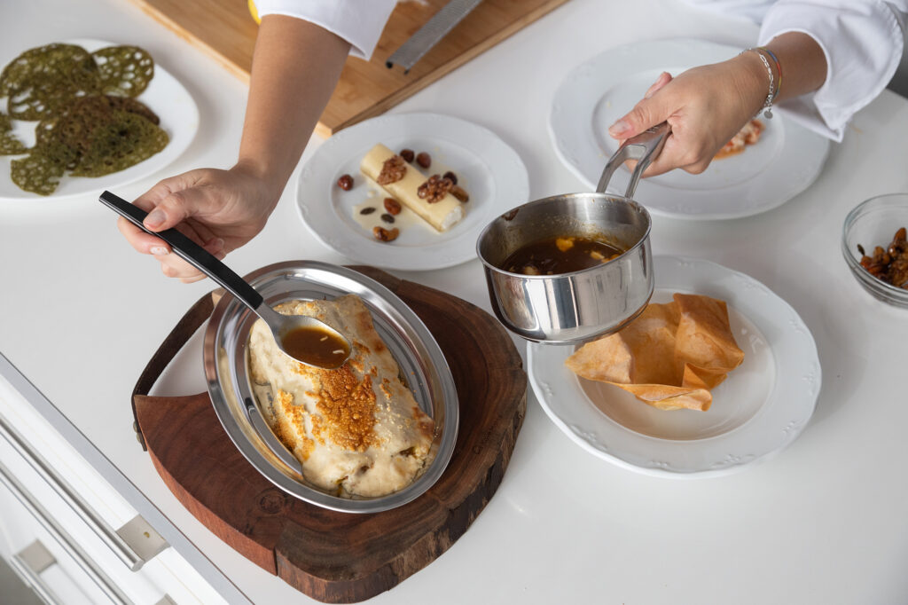 Preparación de plato gourmet con detalle de manos en cocina en Barcelona – fotografía gastronómica profesional por La Fotógrafa