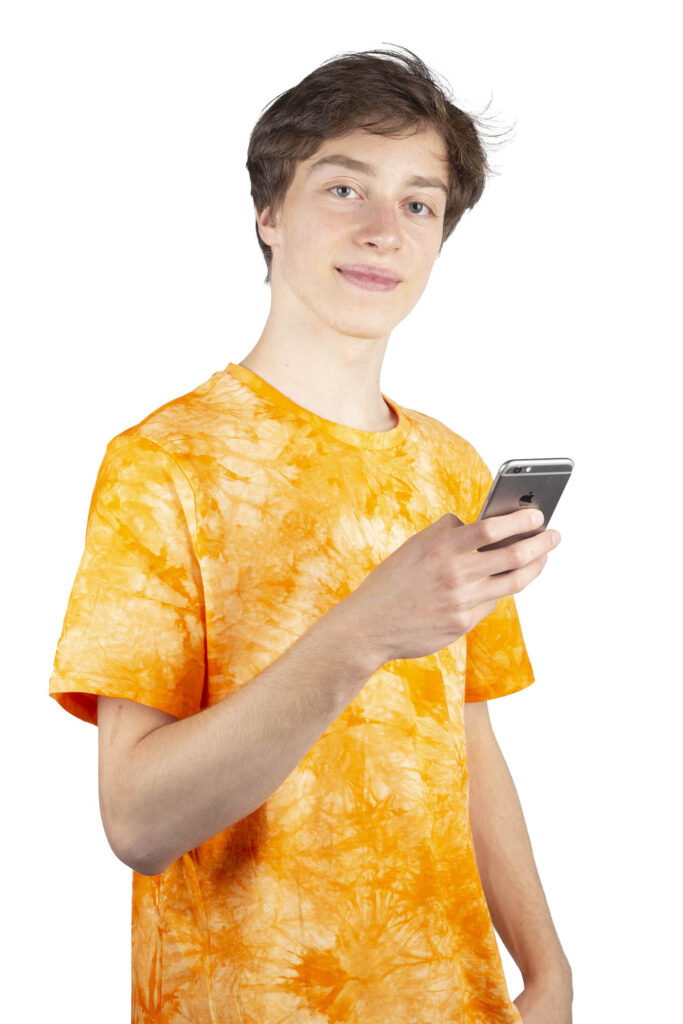 Retrato de chico joven usando smartphone sobre fondo neutro en Barcelona – fotografía lifestyle y generación digital por La Fotógrafa