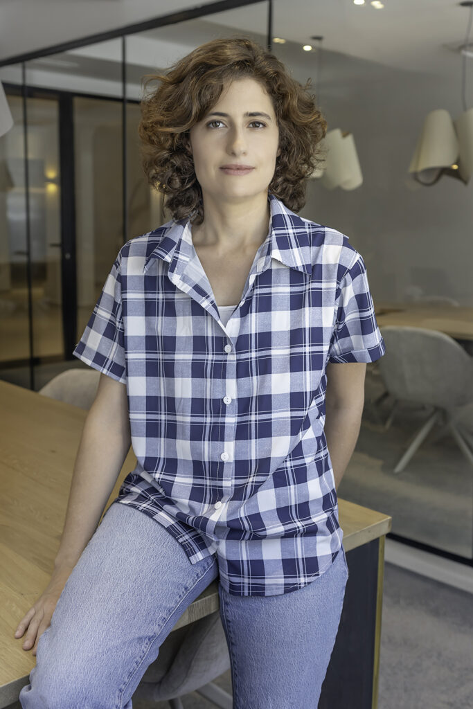 Retrato lifestyle de mujer con camisa de cuadros en oficina luminosa en Barcelona – fotografía de marca personal por La Fotógrafa
