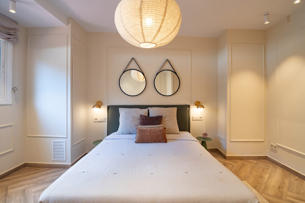 Fotografía inmobiliaria en Barcelona, camara, con dos espejos redondos en la cabecera.